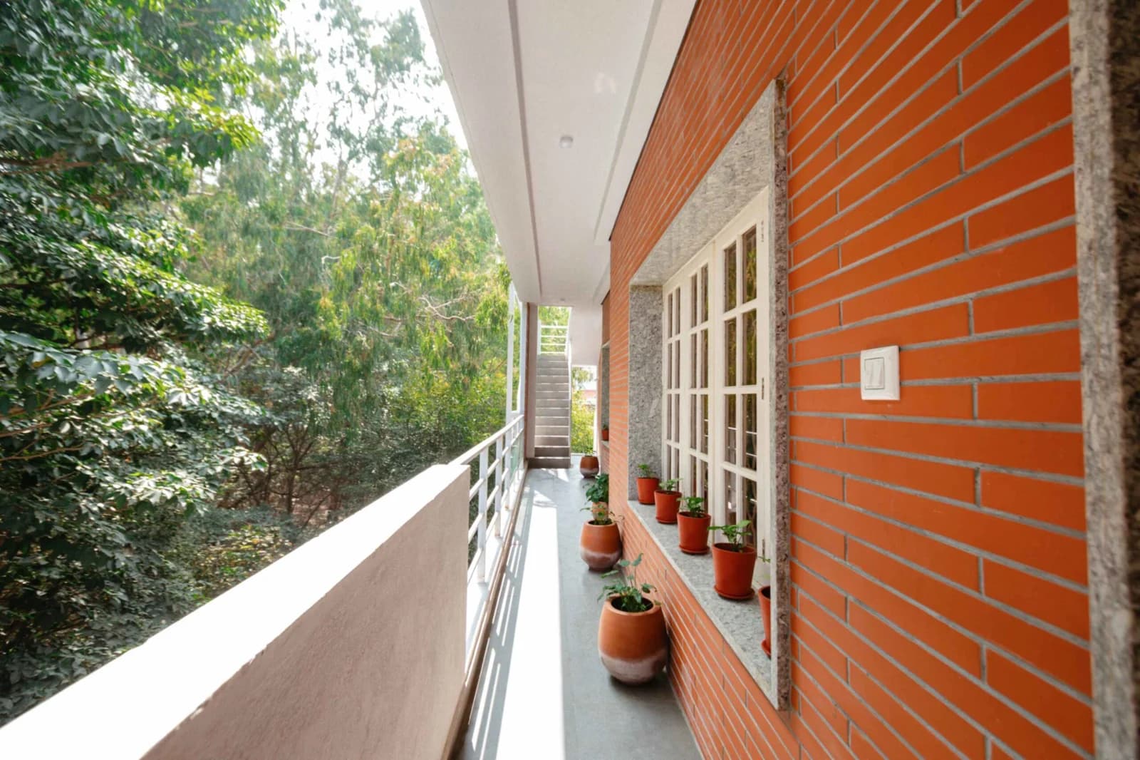PRAAD Suites — the gallery opening onto the tree canopy alongside the building