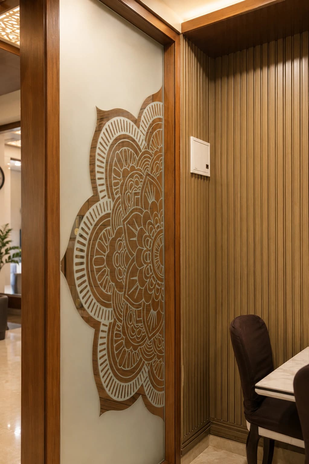 The House of Motifs — etched mandala screen against fluted panelling